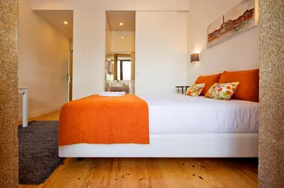 a bedroom with a large white bed and a mirror at MyStay Porto Bolhão in Porto