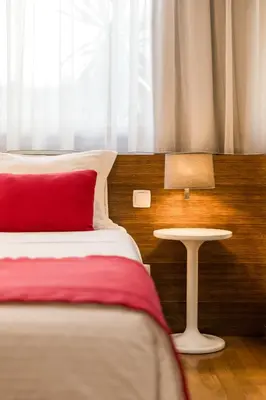 a bedroom with a bed with a red pillow and a table at BRA.com Apartments Oporto Bonfim in Porto