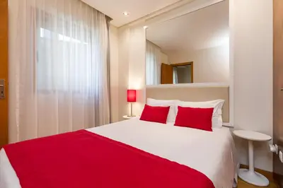 a bedroom with a large bed with red pillows at BRA.com Apartments Oporto Bonfim in Porto