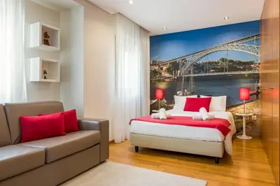 a bedroom with a bed and a couch and a bridge at BRA.com Apartments Oporto Bonfim in Porto