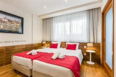 a bedroom with a large bed with red sheets at BRA.com Apartments Oporto Bonfim in Porto