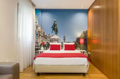 a bedroom with a large bed with a painting on the wall at BRA.com Apartments Oporto Bonfim in Porto