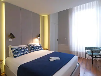a bedroom with a large bed with a blue blanket at New Oporto Apartments - Mouzinho in Porto