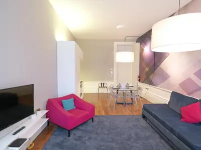 a living room with a couch and a red chair at New Oporto Apartments - Mouzinho in Porto