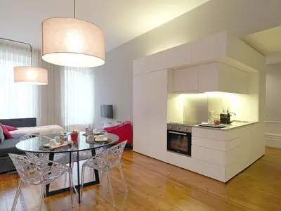 a kitchen and a living room with a table and chairs at New Oporto Apartments - Mouzinho in Porto