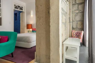 a bedroom with a bed and a green couch at Oporto Welcome Apartments - Santa Catarina in Porto