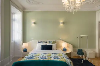 a bedroom with a bed and a chandelier at Oporto Welcome Apartments - Santa Catarina in Porto