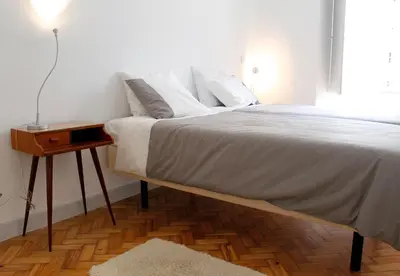 a bedroom with a bed with a nightstand and a bed sidx sidx at Casa da Catedral in Porto
