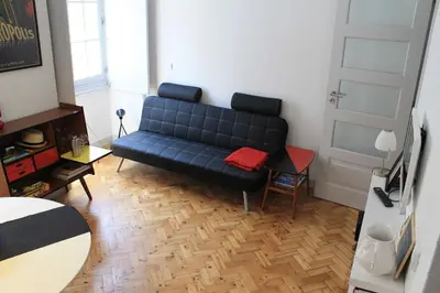 a living room with a blue couch and a table at Casa da Catedral in Porto