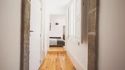 a hallway with a mirror and a bed in a room at BmyGuest - Almada Garden Apartment in Porto
