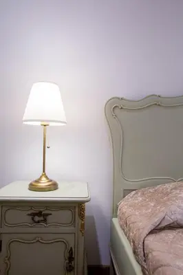 a lamp on a night stand next to a bed at GuestReady - Eiffel Waterfront apartments in Porto