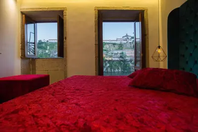 a bedroom with a red bed with two windows at GuestReady - Eiffel Waterfront apartments in Porto