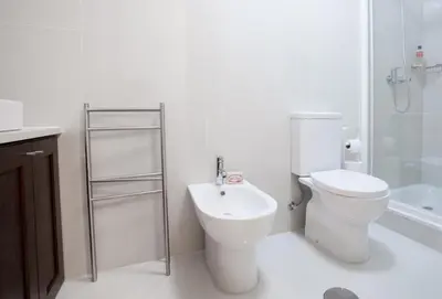 a white bathroom with a toilet and a sink at OPO Trinta e um in Porto