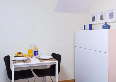 a white dining room table with chairs and a white refrigerator at OPO Trinta e um in Porto