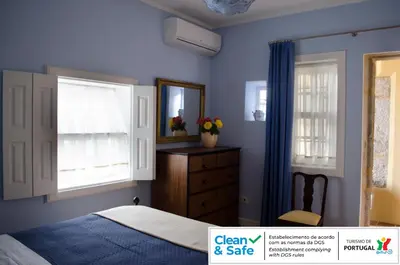 a bedroom with blue walls and a bed and a dresser at Porto.arte downtown apartment in Porto