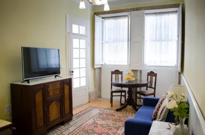 a living room with a tv and a blue couch at Porto.arte downtown apartment in Porto