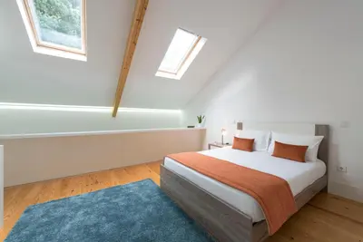 a white bedroom with a bed and a blue rug at Apartment Firehouse by Sweet Porto - Free Parking in Porto