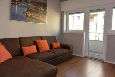 a living room with a brown couch and two orange pillows at Júlio Dinis Flat, by Flat in Porto in Porto