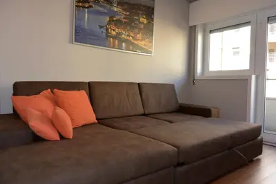 a brown couch with orange pillows in a living room at Júlio Dinis Flat, by Flat in Porto in Porto