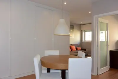 a dining room with a table and white chairs at Júlio Dinis Flat, by Flat in Porto in Porto