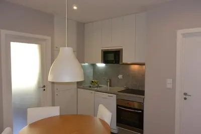 a kitchen with a wooden table and a white kitchen at Júlio Dinis Flat, by Flat in Porto in Porto