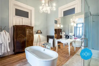 a bathroom with a bath tub and a dining room at Charm Palace Porto in Porto