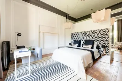 a bedroom with a king sized bed and a desk at Charm Palace Porto in Porto