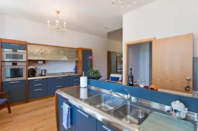a large kitchen with blue cabinets and a sink at Porto Douro River Guest House in Porto