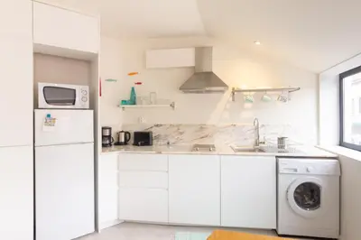 a white kitchen with a sink and a dishwasher at Formosa Flats in Porto