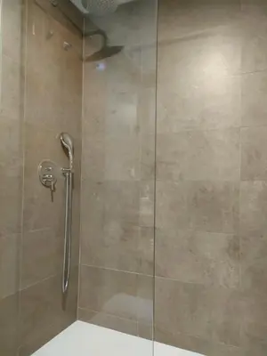 a shower stall with a glass door with a shower at Douro View Apartment in Vila Nova de Gaia