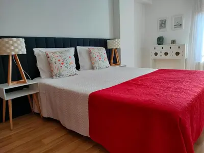 a bedroom with a bed with a red blanket and pillows at Douro View Apartment in Vila Nova de Gaia