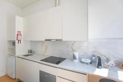 a kitchen with white cabinets and a counter top at Monchique´s Balcony in Porto