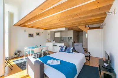 a bedroom with a large bed and a kitchen at Monchique´s Balcony in Porto