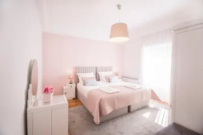 a white bedroom with a bed and a window at the5rooms.porto in Porto