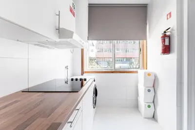 a white kitchen with a sink and a toilet at Casa Trindade in Porto