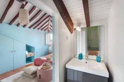 a bathroom with a sink and a living room at Own Places Clérigos Apartments in Porto