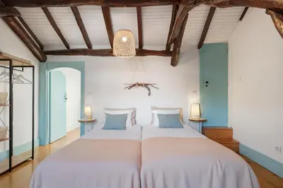 two beds in a room with blue walls and wooden ceilings at Own Places Clérigos Apartments in Porto