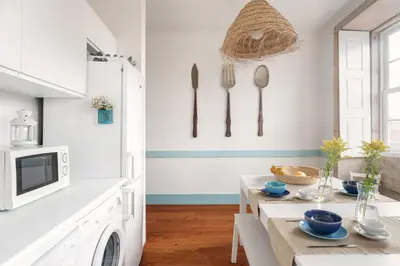 a kitchen with a table and utensils on the wall at Own Places Clérigos Apartments in Porto