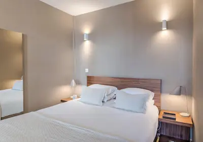 a hotel room with a bed with white sheets and pillows at Oporto Street Sá de Noronha in Porto