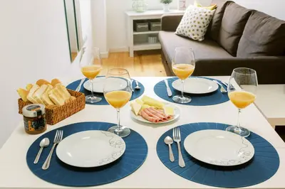 a table with blue and white plates and glasses of wine at PortoVivo Bonjardim Apartamento in Porto
