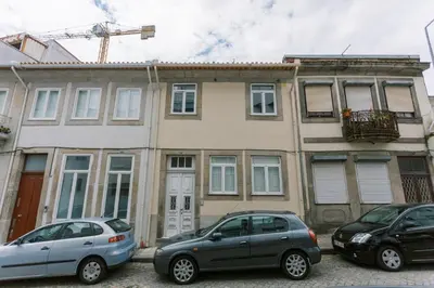 two cars parked in front of a building at PortoVivo Bonjardim Apartamento in Porto