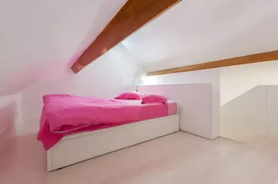 a bed with pink sheets in a white room at Boutique Rentals - Hidden Treasure in Porto