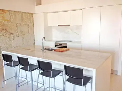 a kitchen with a large island with black bar stools at Boutique Rentals - Hidden Treasure in Porto