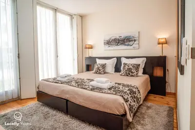 a bedroom with a large bed with two pillows at Locally Yours São Bento Apartments in Porto