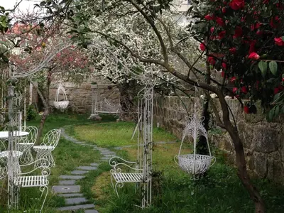 a group of white chairs sitting in a garden at Boavista Eco-Luxury House in Porto
