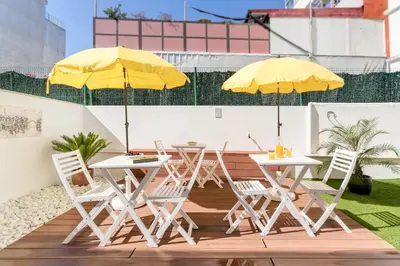 a patio with a table and a yellow umbrella at Antero Quental Residence in Porto