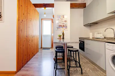 a kitchen and living room with a sink and a stove at Antero Quental Residence in Porto