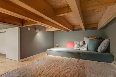 a bed in a room with wooden ceilings and a rug at Janika's Apartment in Porto