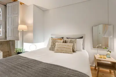 a bedroom with a large white bed with pillows at Janika's Apartment in Porto