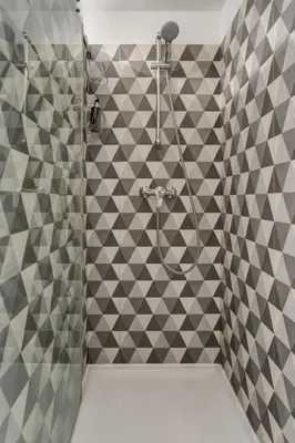a bathroom with a shower with gray and white tiles at Janika's Apartment in Porto